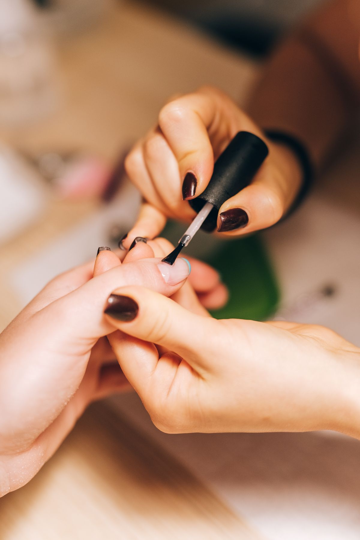 Nail artist applying polish during a manicure